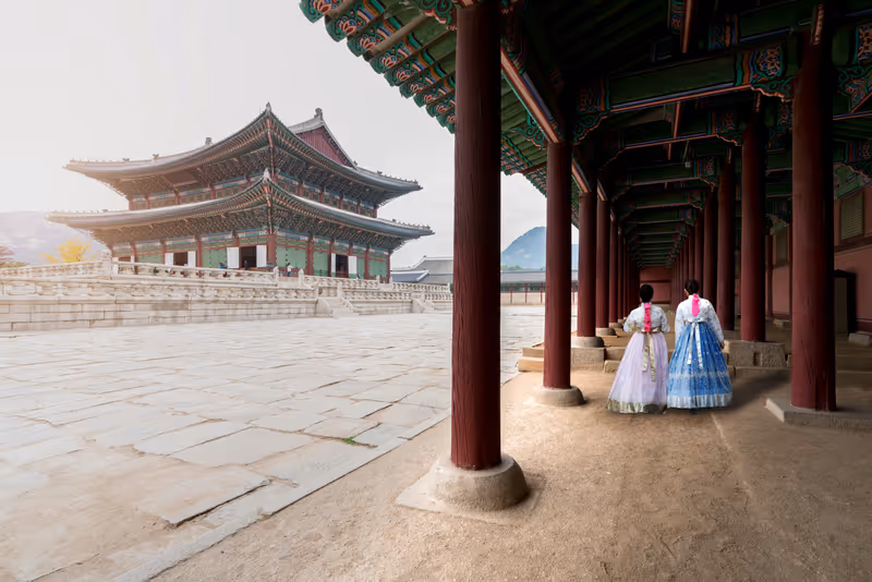 Asian Korean woman dressed Hanbok in traditional dress walking in Gyeongbokgung Palace in Seoul, South Korea.