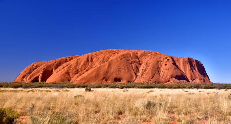 Uluru Kata Tjuta National Park, Northern Territory/Australia August 5th 2018. A view of Uluru from the Western End taken at 3.00 p.m. during winter. Showing typical vegetation in foreground.