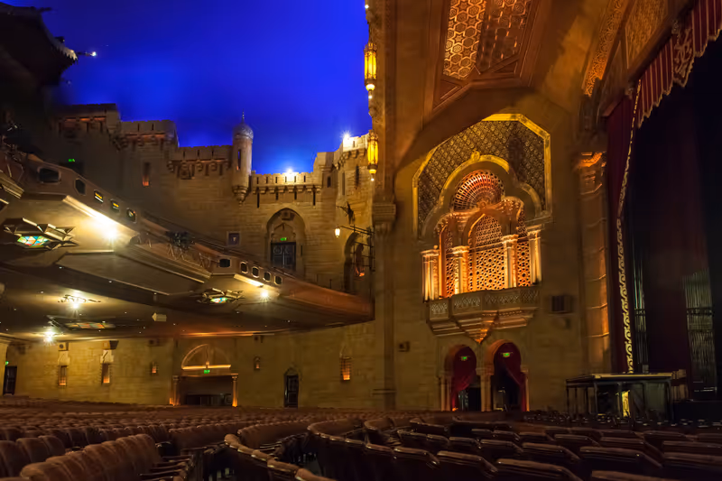 Atlanta, Georgia, USA – July 30, 2015: Panoramic view of the stalls, stage and blue lightened ceiling of the Oriental style decorated Fox Theater, Midtown