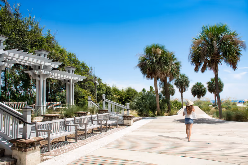 Girl walking to the beach on summer trip. Woman enjoying vacation alone.. Coligny Beach Park, Hilton Head Island, South Carolina, USA