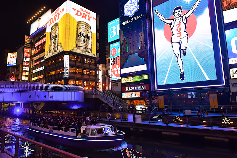 Osaka,Japan-02 14 2018:Night scene of tour boat on the DÅ�tonbori canal,a popular nightlife and entertainment area characterized by its eccentric atmosphere and large illuminated signboards.