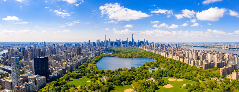 Aerial view of the Central park in New York with golf fields and tall skyscrapers surrounding the park.