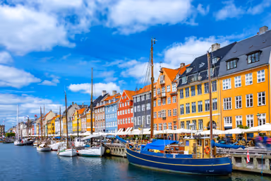 Scenic summer view of Nyhavn pier with colorful buildings and boats in Old Town of Copenhagen, Denmark