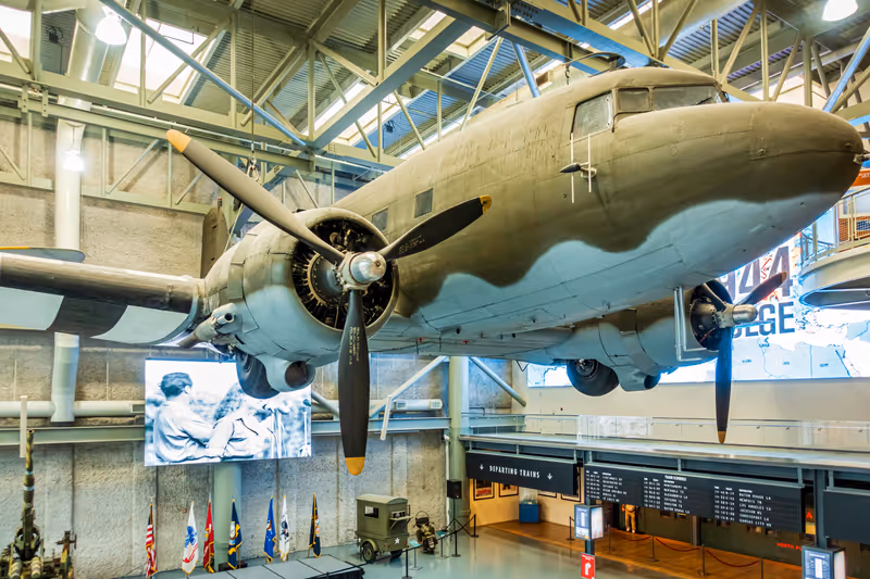 New Orleans, USA - Dec 18, 2017: A life-size US World War II plane hanging over the lobby of the National WWII Museum. Entrance ticket booths below.