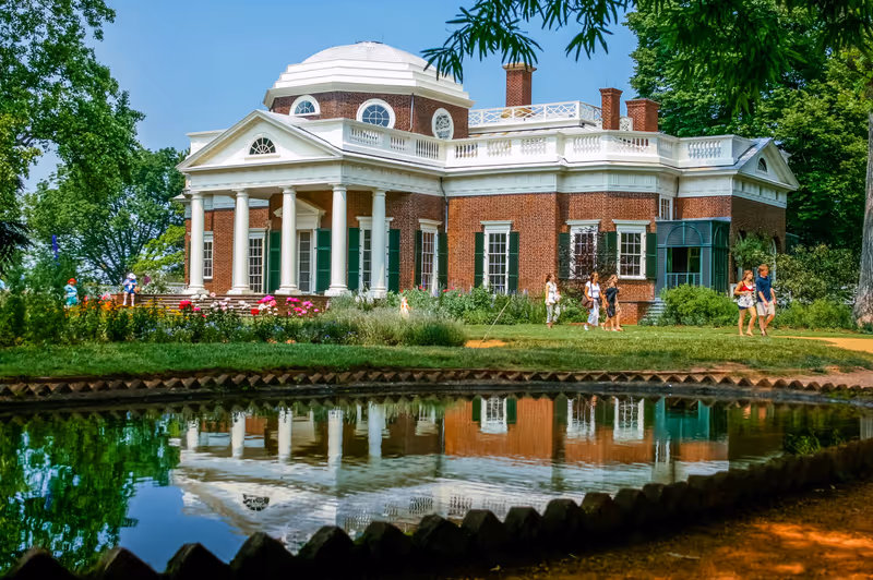 Monticello, Virginia/USA - 05/25/2007; View of Thomas Jefferson's estate Monticello in summer; visitors walking in front of the building; building reflects in pond in front of it