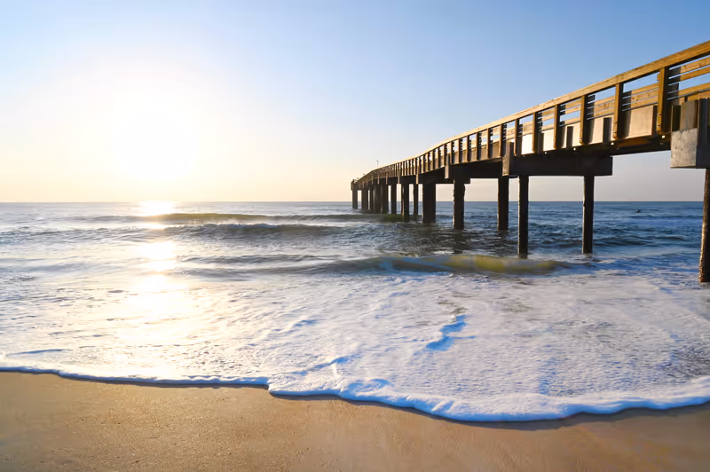 Pier at St. Augustine Beach in Florida as the sun rises above the horizon