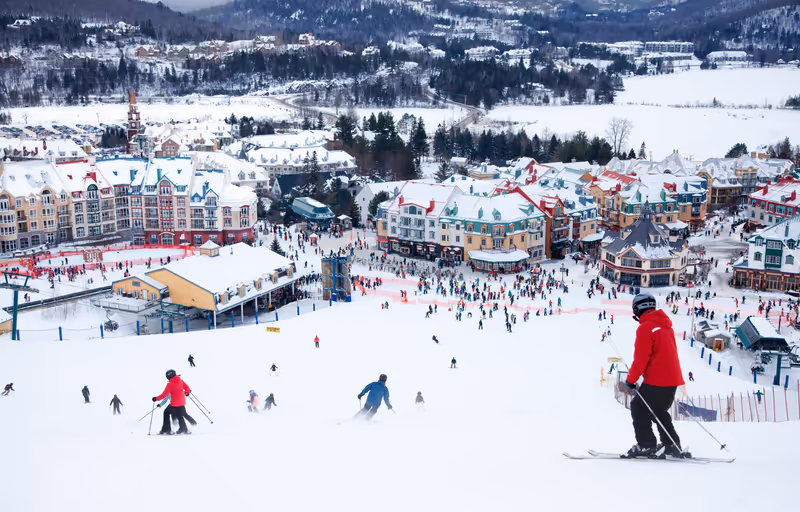 MONT-TREMBLANT, QC, CANADA -FEBRUARY 9: Skiers and snowboarders are sliding down the main slope at Mont-Tremblant Ski Resort on February 9, 2014. It is the best ski resort in Eastern North America.