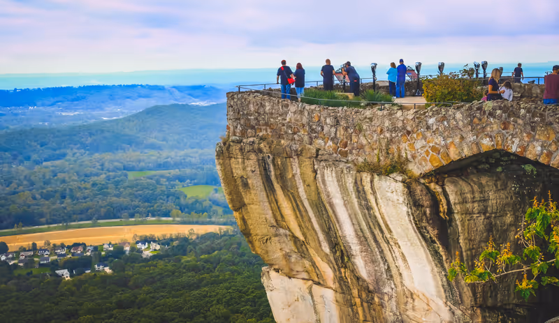View of Lookout Mountain cliff in Tennessee with small figures of people looking at the rural landscape underneath in summer