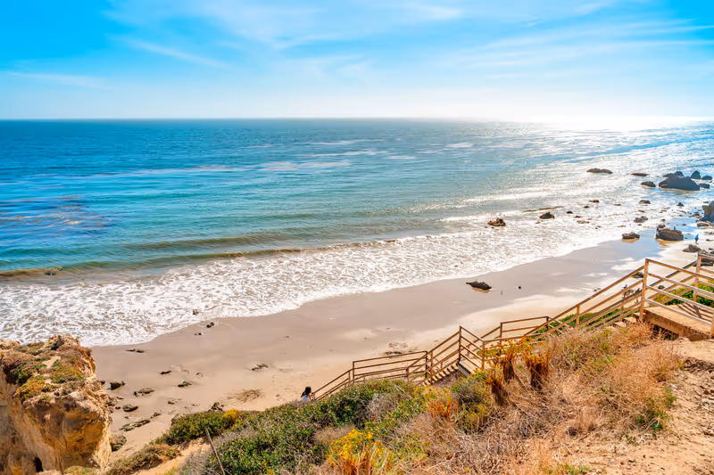 Matador beach and beautiful landscape with rocks and ocean against blue sky, California