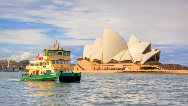 SYDNEY, AUSTRALIA - MAY 20, 2010: A ferry passes Sydney Opera House, Australia's most recognisable building, on its way to Circular Quay.