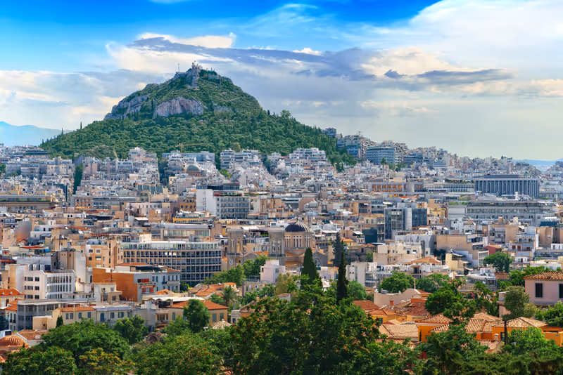 Beautiful cityscape of the Greek capital - Athens city against the backdrop of Mount Lycabettus and blue sky on a sunny afternoon. Lycabettus. Greece