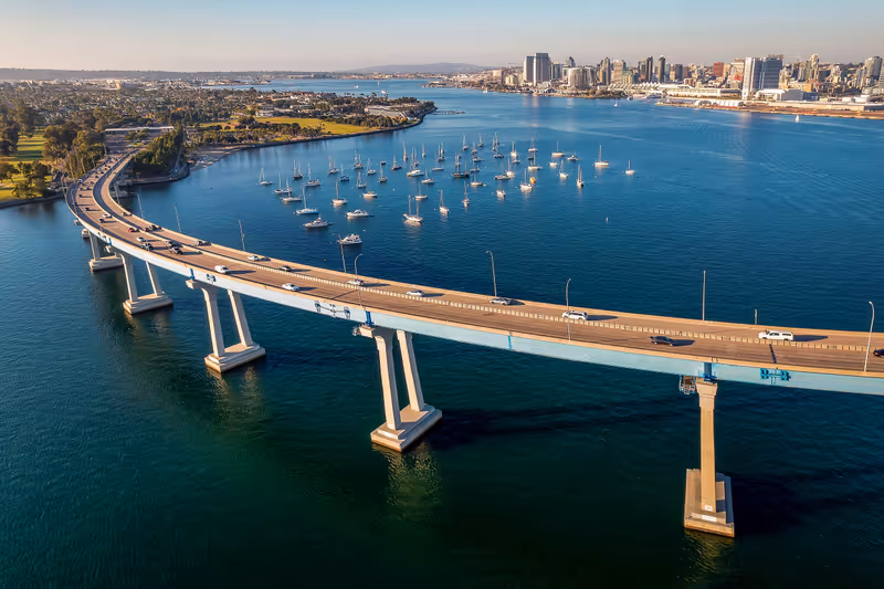 Aerial view of Coronado Bridge in San Diego bay in southern California on a warm sunny day with boats in the bay and cars crossing the bridge