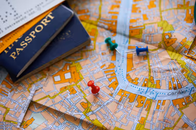 pins marking travel itinerary points on map and passport