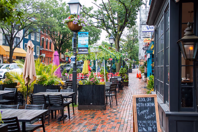 Alexandria, Virginia, USA - 23 June 2023: Tables and chairs on the sidewalk and street in front of restaurants on King Street in Old Town Alexandria Virginia.