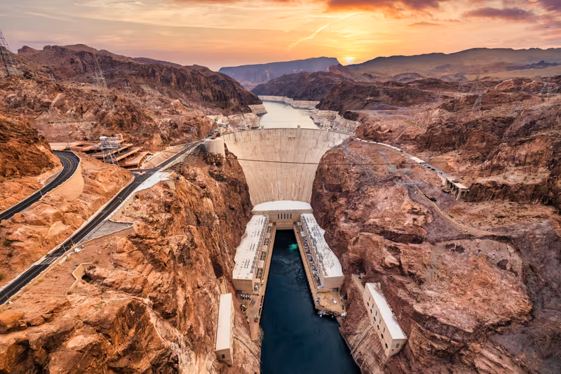 Hoover Dam on the Colorado River straddling Nevada and Arizona at dawn, from above.