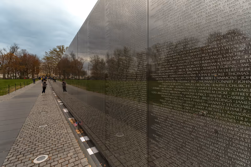 Washington DC - US - Mar 23, 2024 Tourists visiting the Vietnam Veterans Memorial. black granite walls designed by Maya Lin, engraved with the names of those service members who died or remain missing