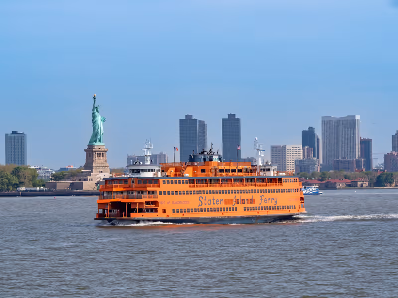 New York, New York, USA - May 14, 2024: Staten Island ferry and the statue of liberty with Manhattan skyline.
