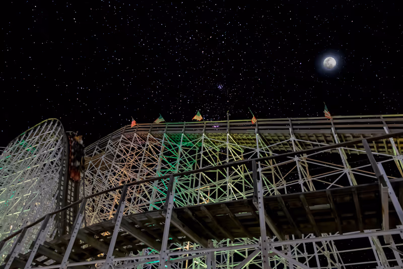 Orlando, Florida, USA - Mar 5, 2023: A wooden roller coaster at Fun Spot America (Old Town) in Kissimmee, near Orlando, Florida is seen under the stars and moonlight.