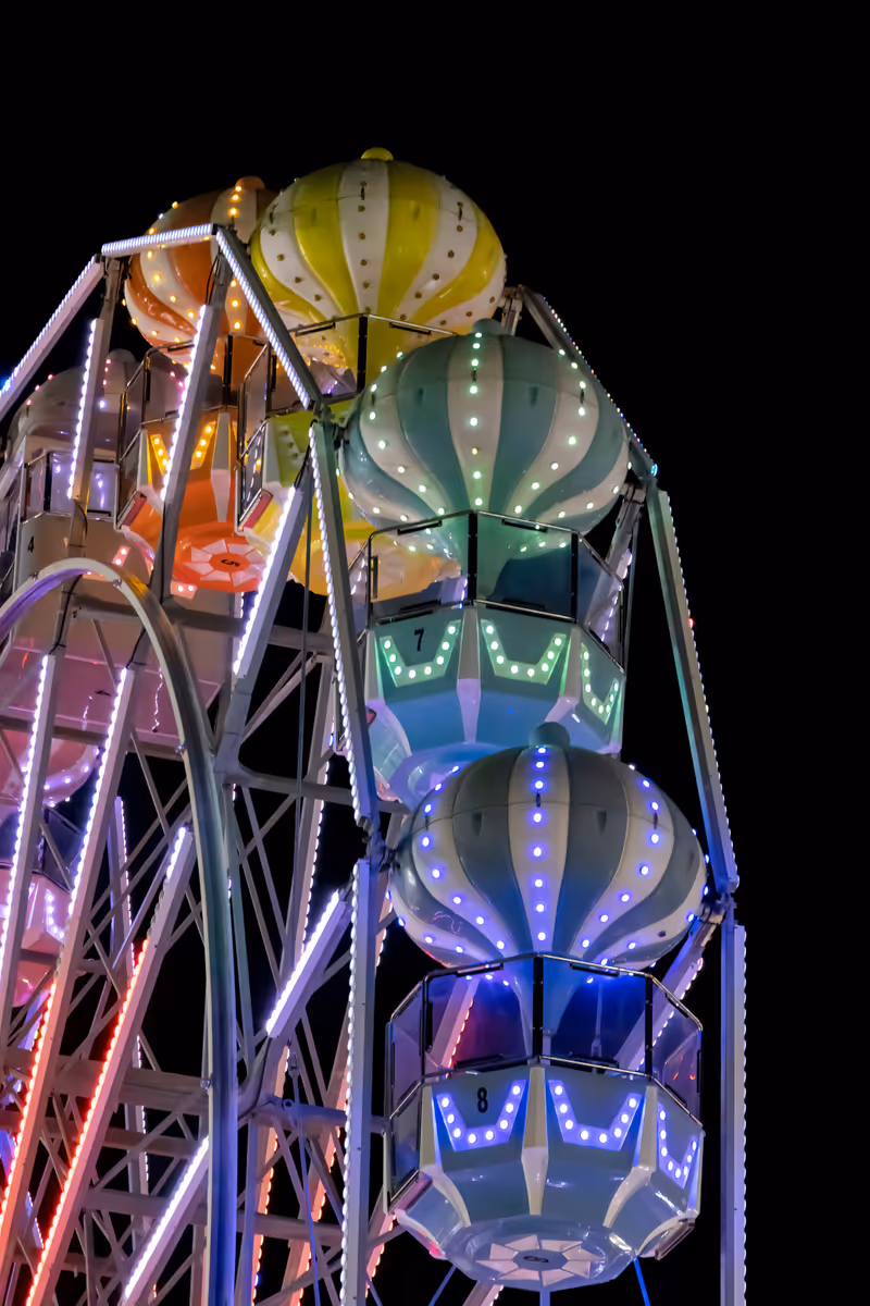 A ferris wheel is lit up in multi colour at night at Fun Spot America (Old Town) in Kissimmee near Orlando, Florida.