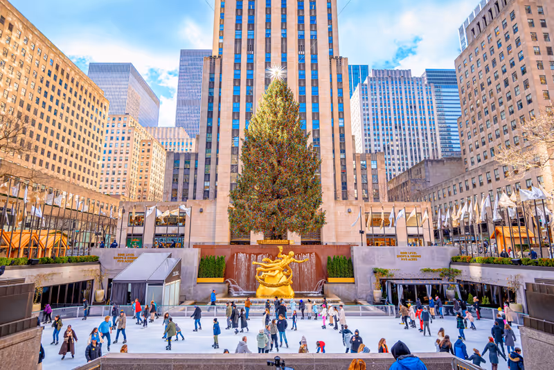 New York City, NY, USA- December 27, 2023: People play ice skate in the Rink at Rockefeller Center under Christmas tree,