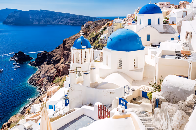 Oia town on Santorini island, Greece. Traditional and famous white houses and churches with blue domes over the Caldera, Aegean sea