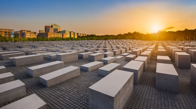 BERLIN - JULY 17 2015: Panoramic view of famous Jewish Holocaust Memorial near Brandenburg Gate in golden evening light with blue sky at sunset in summer on July 17, 2015 in Berlin Mitte, Germany
