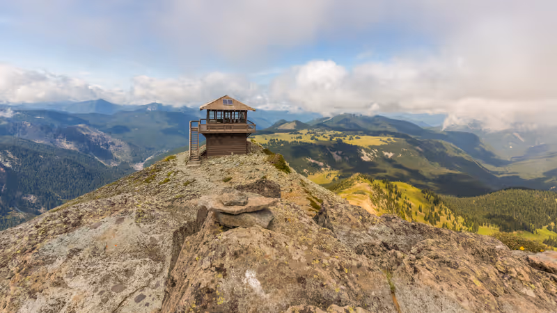 Rocky slopes in the mountains. Amazing view at the peaks which rose against the cloud sky. Wooden lookout tower on the top. MOUNT FREMONT LOOKOUT TRAIL, Sunrise Area, Mount Rainier