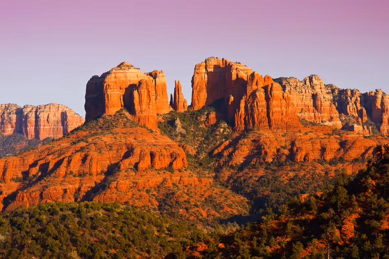 The view of Cathedral Rock in Sedona, Arizona. The towering rock formations stand out like beacons in the dimmed landscape of the Red Rock State Park.