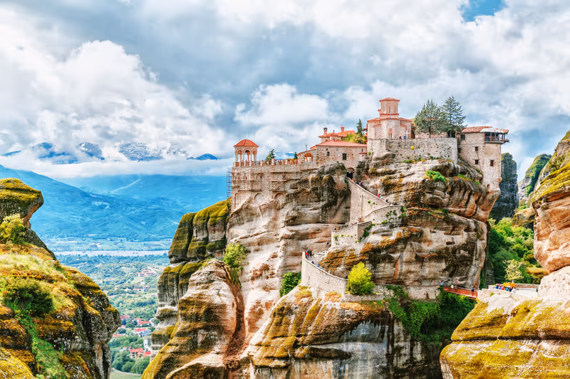 Monastery Meteora Greece. Stunning summer panoramic landscape. View at mountains and green forest against epic blue sky with clouds. UNESCO heritage list object.