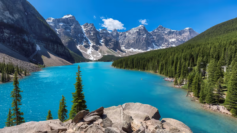 Beautiful turquoise waters of the Moraine lake with snow-covered rocky mountains in Banff National Park of Canada.