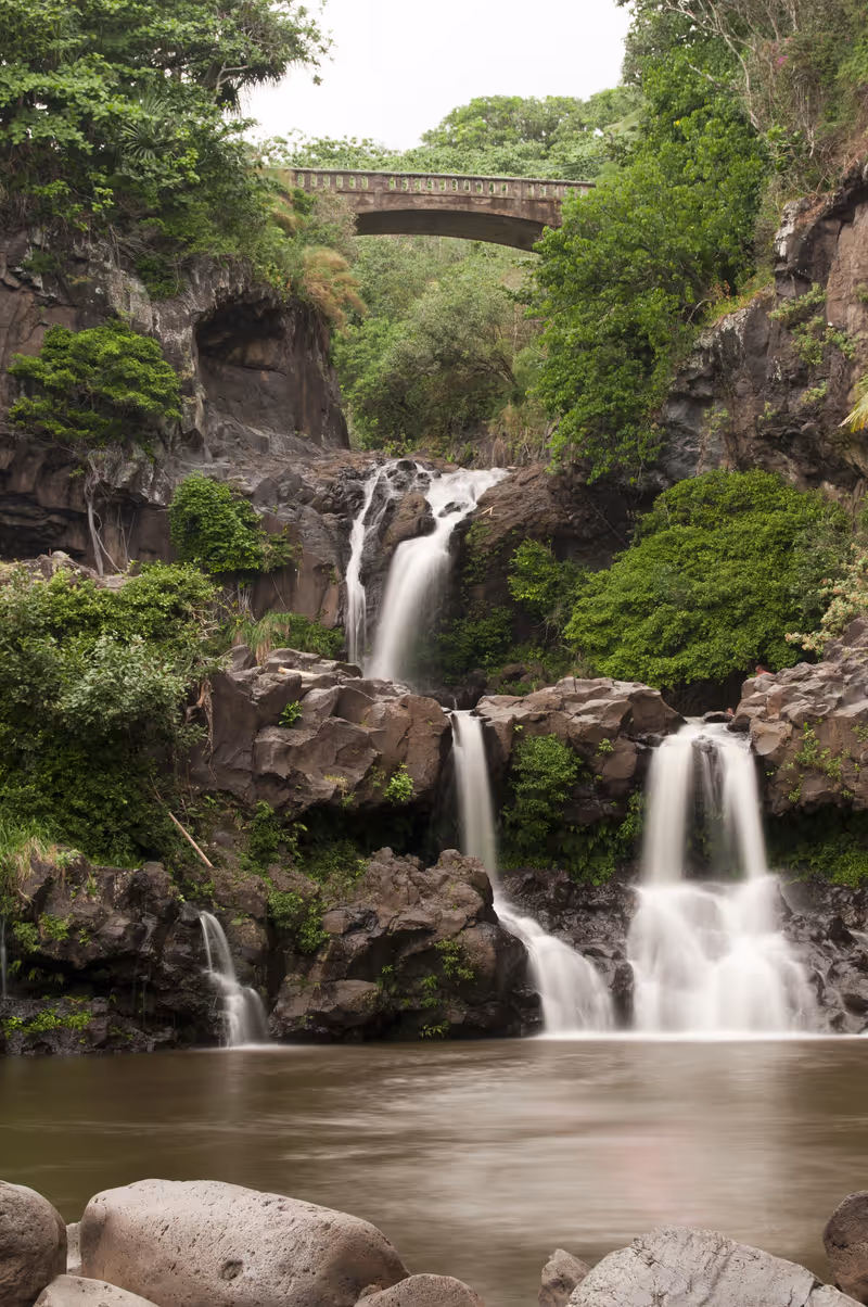 Seven Sacred Pools in Hana, Maui, Hawaii. Beautiful vertical long exposure photo of several waterfalls and streams with green plants and rocks.